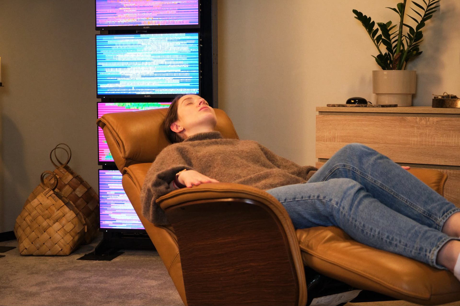 Woman resting in a recliner in front of the EESystem screens